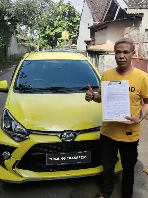 Handover of a yellow Toyota Agya to a Tunjung Transport customer